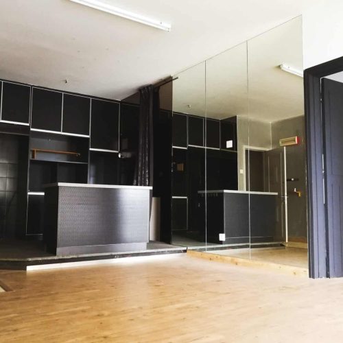 interior of a black kitchen island with glass wall and wooden flooring
